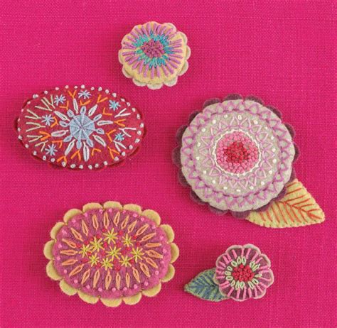 four different types of embroidered flowers on a pink background