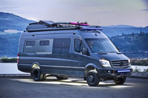 a mercedes van parked in front of a lake