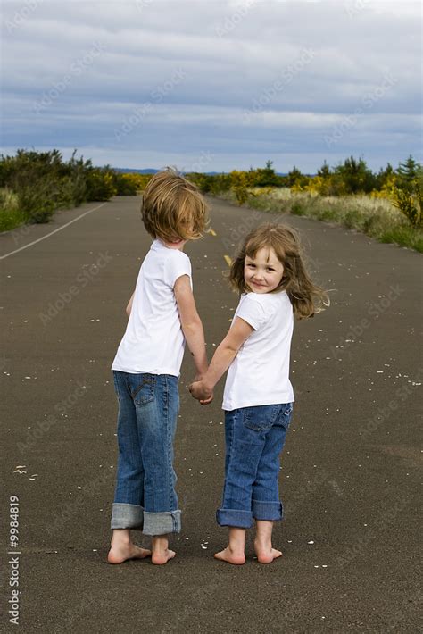 Barefoot kids walking down the road holding hands Stock Photo | Adobe Stock