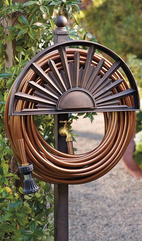 a clock that is sitting on top of a pole in front of some bushes and trees