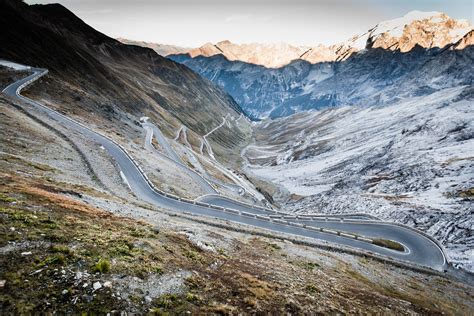 a mountain road winding down the foot of a valley, serpentine mountain road 4k HD Wallpaper