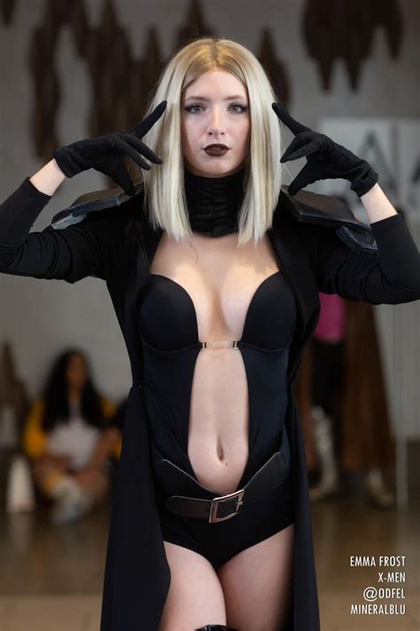 a woman in a black outfit with her hands on her head