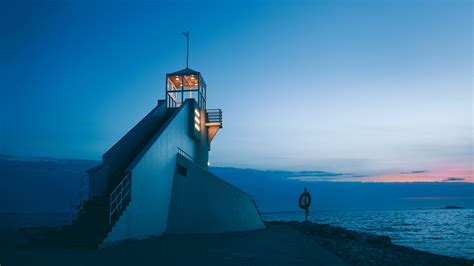 a lighthouse beacon with illuminated lights in front of a blue sky and ...