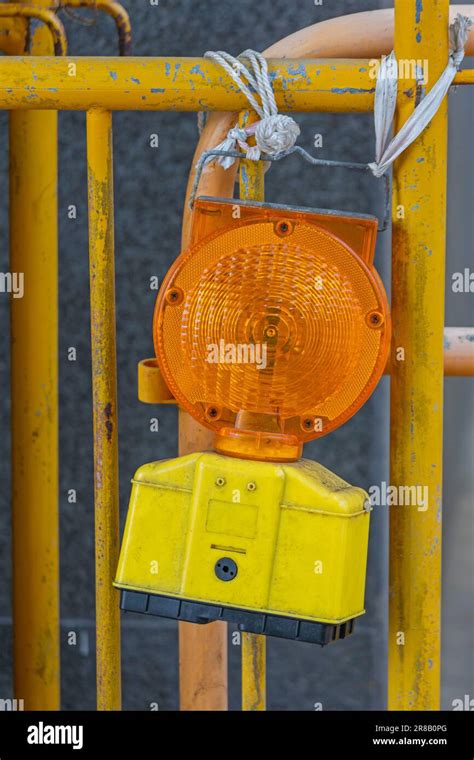 Flashing Yellow Warning Light at Construction Site Fence Stock Photo - Alamy