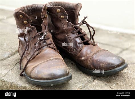 an old pair of brown leather boots with tatty laces Stock Photo - Alamy