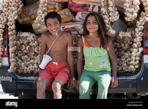 Gypsy kids sitting on the back of a van selling dried garlic cloves ...