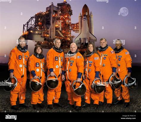 Group portrait of the STS-118 space shuttle crew astronauts in orange ...