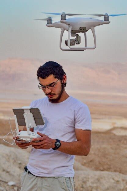 Premium Photo | Young man operating flying with drone