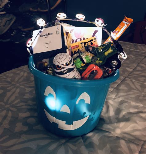 a blue bucket filled with various items on top of a table