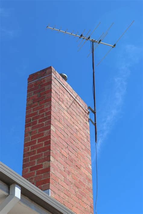 An Analog Television Antenna on a Brick Chimney in a Blue Sky Stock ...