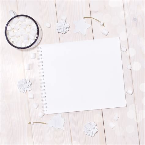 Premium PSD | Notepad mockup with white decorations on wood table