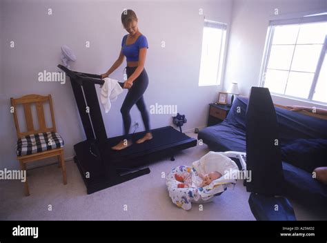 Mother running on treadmill in bedroom with baby Stock Photo - Alamy