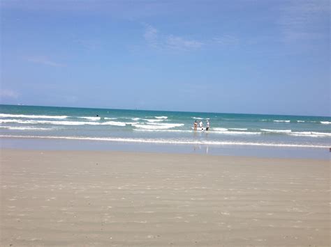 two people are standing in the water at the beach