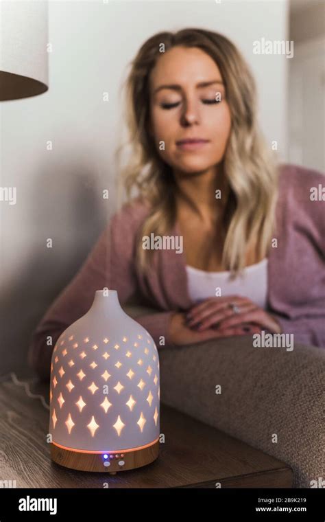 Young woman smelling her essential oil diffuser Stock Photo - Alamy