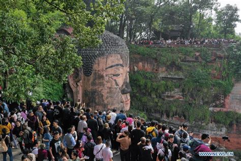 People view statue of Leshan Giant Buddha in SW China's Sichuan