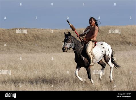 A Native American Indian with a spear riding horseback in South Dakota Stock Photo - Alamy