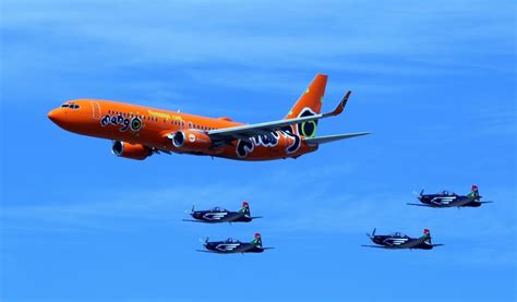 orange commercial plane and 4 black jet planes free image | Peakpx