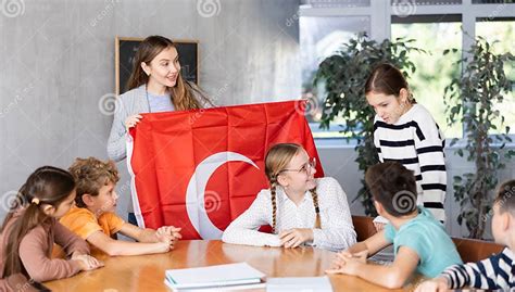 Female Teacher Working with Teenage Students in School Class, Talking about National Flag of ...