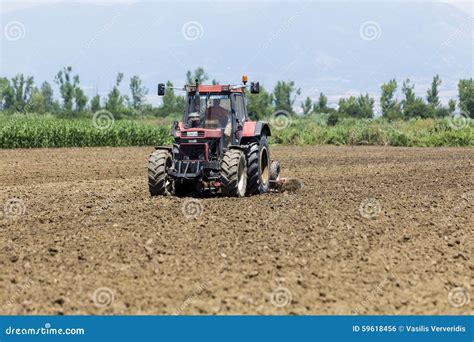 A Tractor Working Planting Wheat in the Fertile Farm Fields of G ...