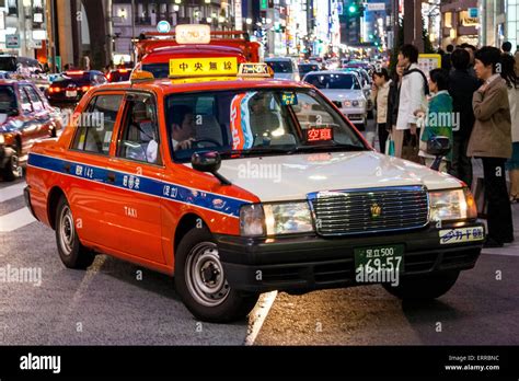 Tokyo Ginza at night, a red and white taxi turning into side street in ...