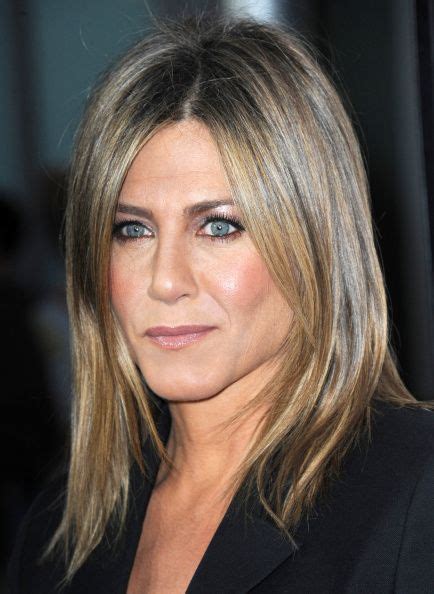 Jennifer Aniston with tightlined eyes, silver eyeshadow, her signature sleek blowout and mau ...