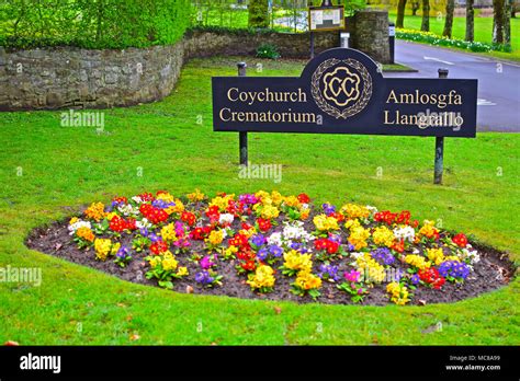 Beautiful & colourful border flowers in front of the bilingual sign for Coychurch Crematorium ...