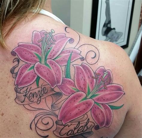 the back of a woman's shoulder with pink flowers on it and words written in cursive writing