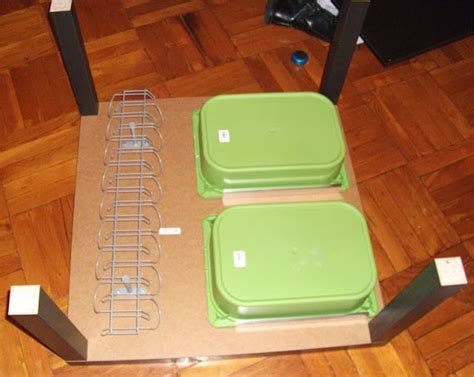 two green containers sitting on top of a wooden table next to speakers and a laptop