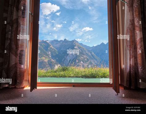 Mountain landscape view trough window with curtains in cozy home ...