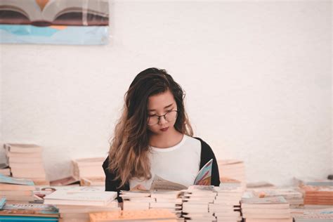 Photo of Woman Reading Book in Room Full of Books · Free Stock Photo