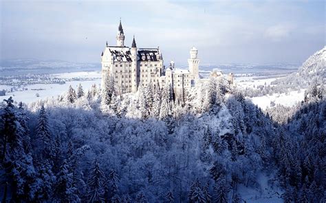 a castle is surrounded by snow covered trees