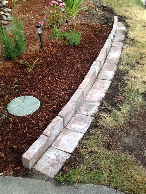 New flower bed border made with pavers.....this style allows the lawnmower to get along the ...