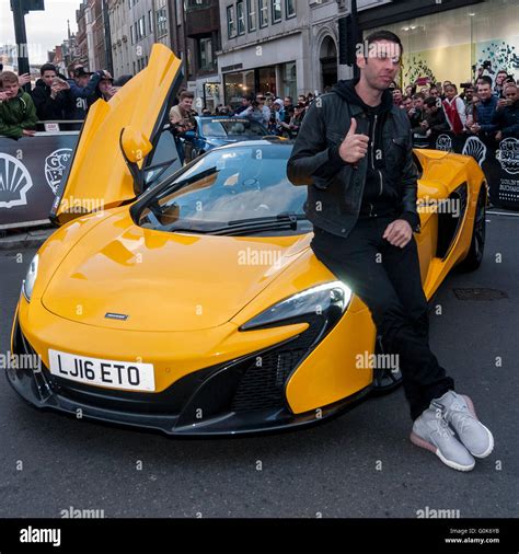 London, UK. 2 May 2016. English rapper, Example, poses beside his car as supercars in the ...