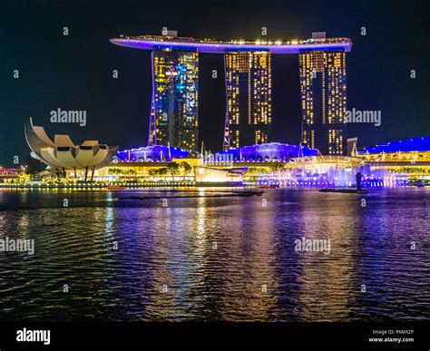 View at night across Singapore Marina Bay towards the illuminated Marina Bay Sands hotel Stock ...