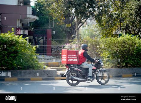 Zomato delivery boy with red hot box for food on a bike zooming at high ...