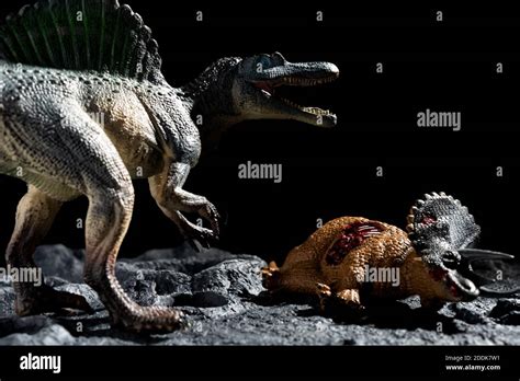 spinosaurus with a triceratops body on a ground with craters Stock Photo - Alamy