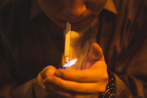 Man lighting cigarette for smoking in light of lamp · Free Stock Photo