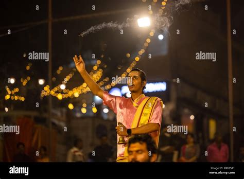 Ganga aarti, Portrait of an young priest performing river ganges evening aarti at assi Ghat in ...