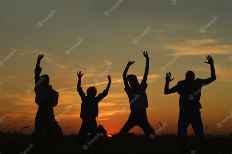 Premium Photo | Family holding hands looking at sunset in field