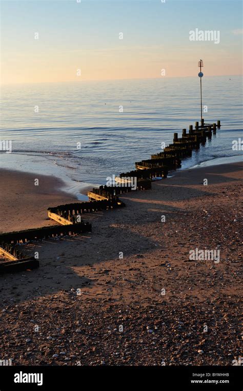 North sea sunset over groins, beach, high tide, Norfolk skies Stock Photo - Alamy