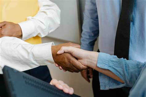 Multiracial colleagues shaking hands at work · Free Stock Photo