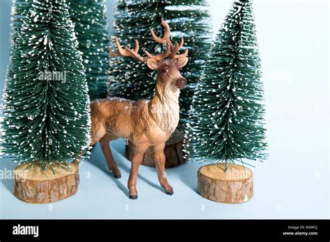 Snowy forest firs and reindeer blue Stock Photo - Alamy