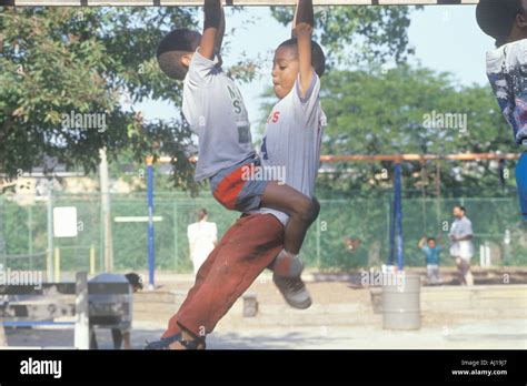 Two African American children playing on playground equipment in ...