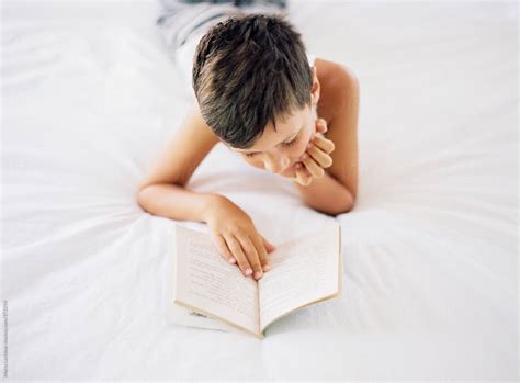 "Boy Lying In Bed Reading A Book" by Stocksy Contributor "Marta ...