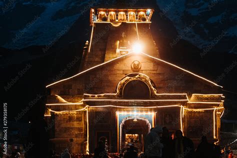 View of the Kedarnath temple lights at night with mountains in the background in Uttarakhand ...