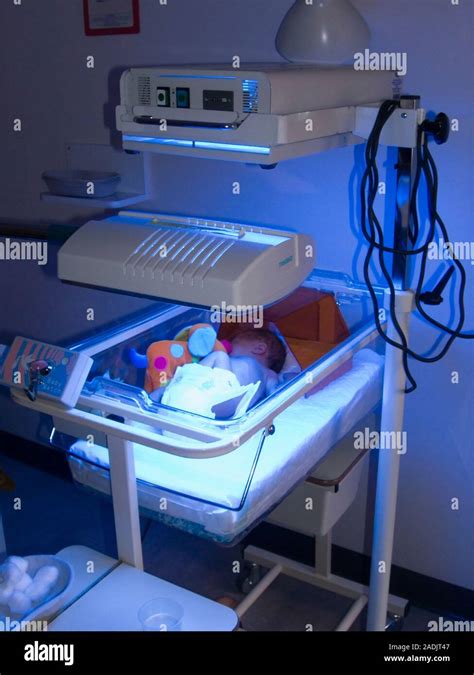 Neonatal jaundice treatment. Baby in an incubator receiving blue light ...