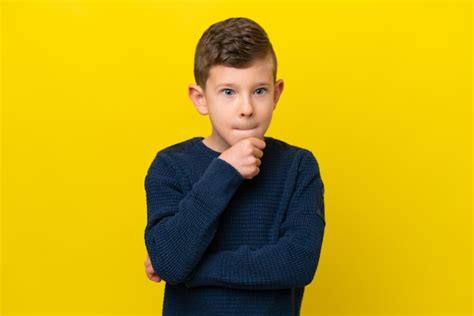 Premium Photo | Little caucasian boy isolated on yellow background having doubts and thinking