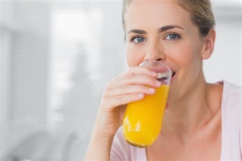 Premium Photo | Cheerful woman drinking orange juice