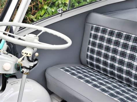 the inside of a small car with a steering wheel and seat upholstered in ...