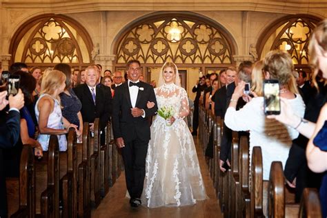 a bride and groom walk down the aisle as guests take pictures on their cell phones